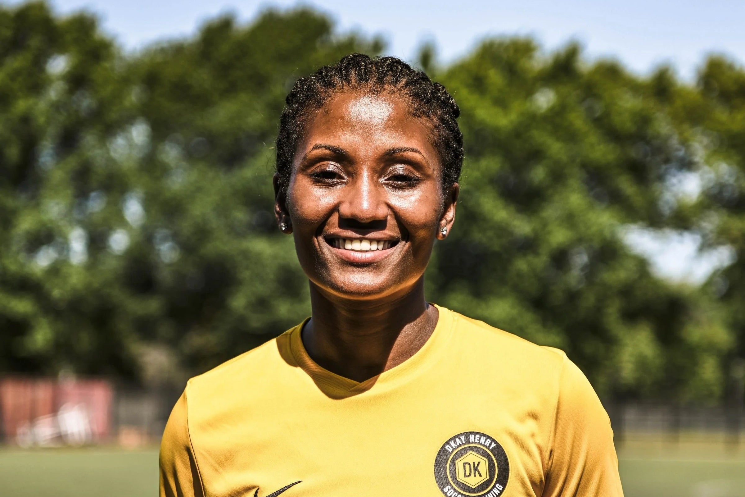 Dkary Henry wearing a yellow sports jersey with 'DKay Henry Soccer Training' on a soccer field.